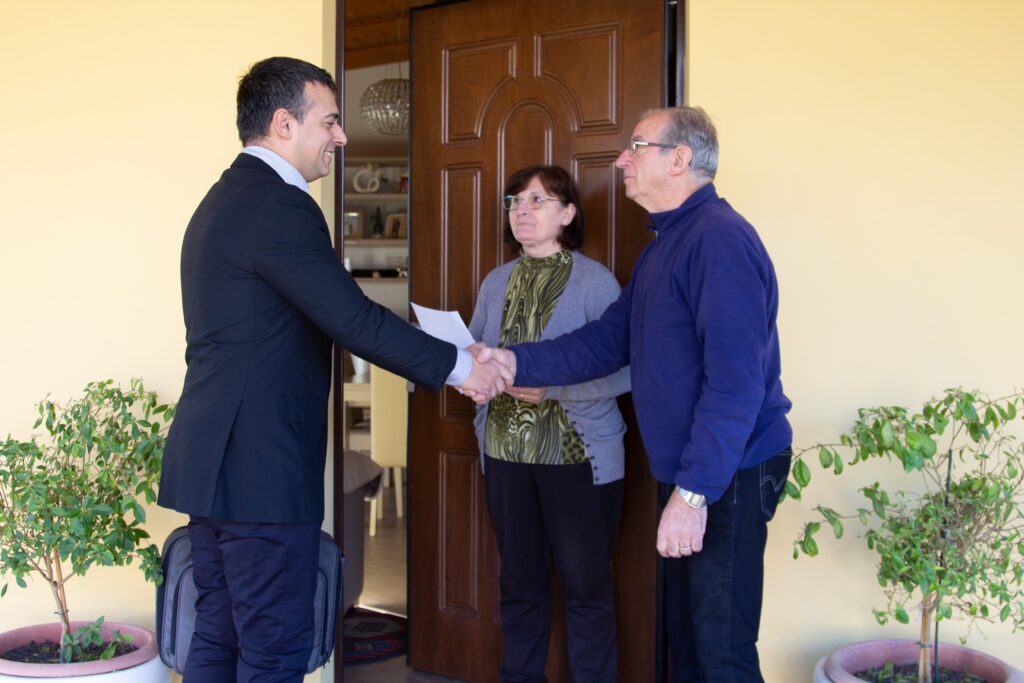 A door-to-door sales representative talking to the customers.